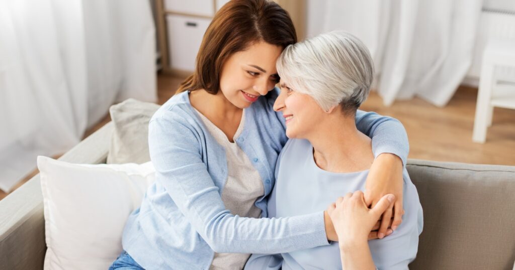 A younger woman embraces an older woman, sharing a loving moment.
