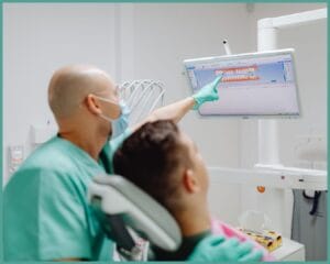 Dentist showing dental x-ray to a patient in clinic.